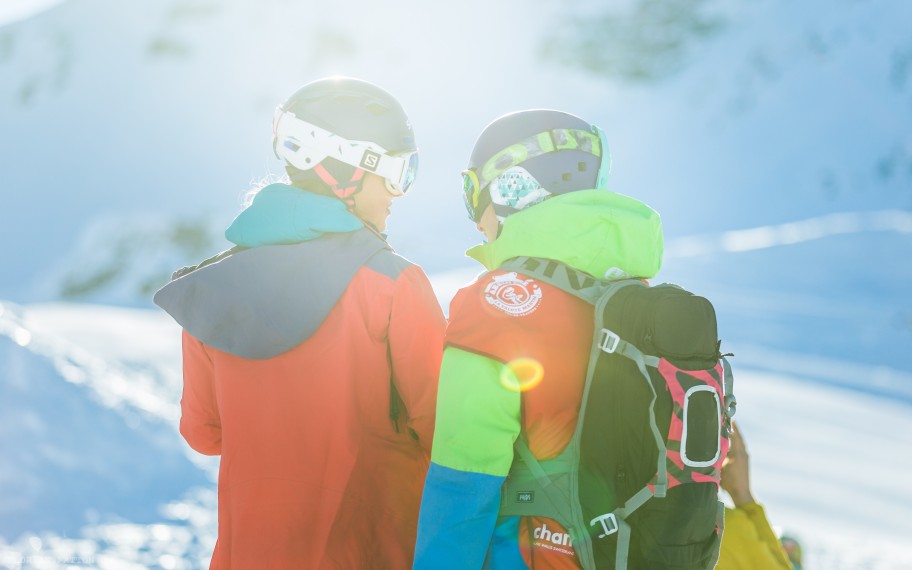 Two people dressed in snow gear in a resort