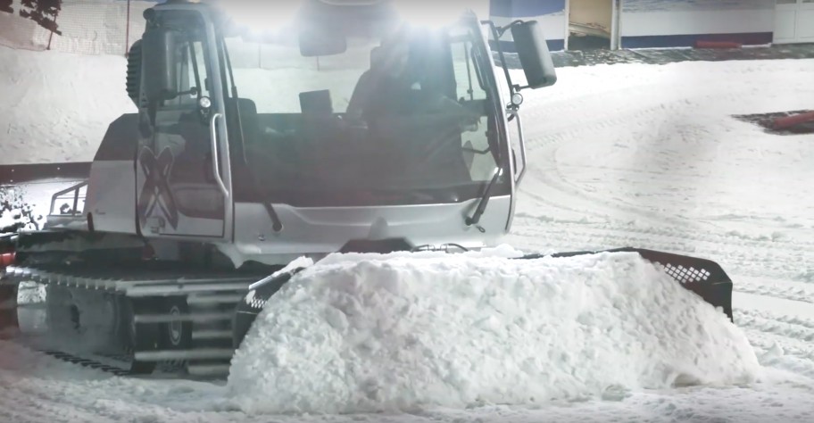 Snow groomer pushing snow on an indoor slope near London