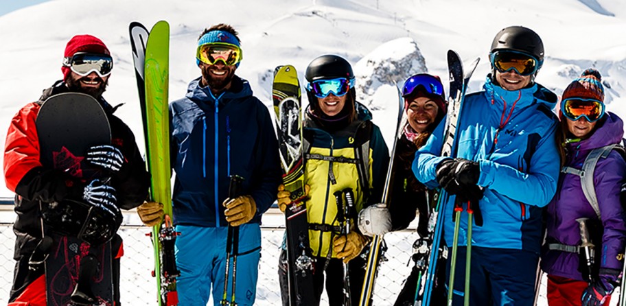 Group of skiers/snowboarders posing for a photo in the mountains