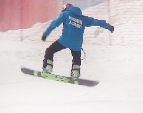 Freestyle coach jumping in the air on their snowboard
