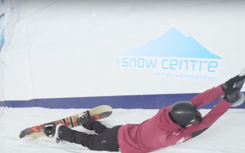 Snowboarder being dragged up an indoor slope near London by button lift