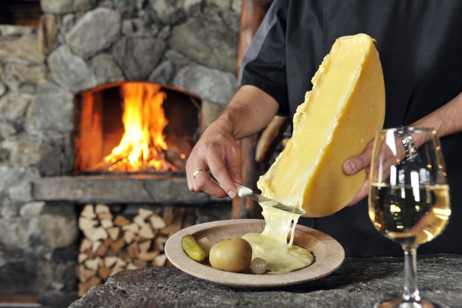 Melted cheese being scraped onto a side plate