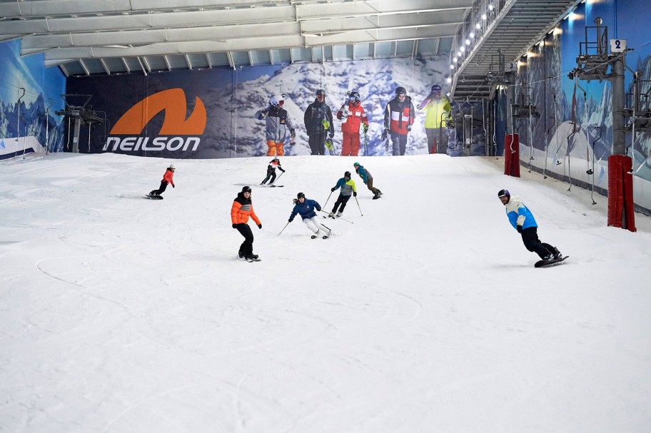 People skiing and snowboarding on indoor slope in Hemel Hempstead