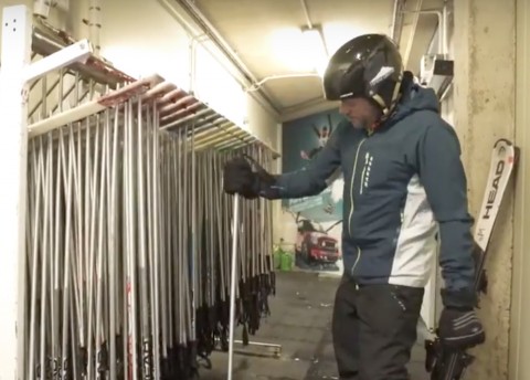 Person selecting ski poles from a rack