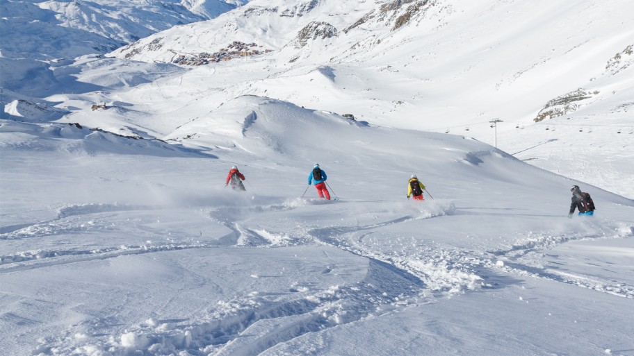 Group of skiers skiing down snowy mountain
